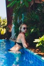 Beautiful Woman Relaxing In Swimming Pool Water. Girl With Healthy Tanned Skin, Gorgeous Face, And Wet Hair Enjoying Royalty Free Stock Photo