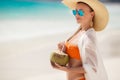 Beautiful woman removes thirst with coconut milk. Royalty Free Stock Photo