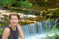 Beautiful woman resting near small waterfall Royalty Free Stock Photo