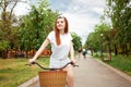 A beautiful woman rides her bike in the park. Rent transport for the day. Summer, spring. The happy girl smiles. Sport