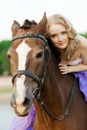 Beautiful woman riding a horse at sunset on the beach. Young beauty girl with a horse in the rays of the sun by the sea. Royalty Free Stock Photo