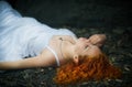 Beautiful woman at the rocky beach in a white dress. Royalty Free Stock Photo