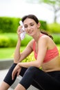 Beautiful woman runner has used a white towel wipe her face after running in the garden