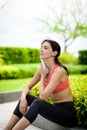 Beautiful woman runner has used a white towel wipe her face after running in the garden