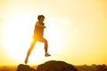 Beautiful Woman Runner Jumping from the Rock on the Mountain Trail at Hot Summer Sunset. Sport and Active Lifestyle Royalty Free Stock Photo