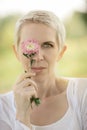 Beautiful woman in a rural field scene outdoors, with flowers