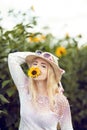 Beautiful woman in a rural field scene outdoors, with sunflower and sunhat Royalty Free Stock Photo