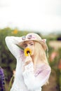 Beautiful woman in a rural field scene outdoors, with sunflower and sunhat Royalty Free Stock Photo