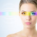 Beautiful woman`s face with rainbow light on eyes