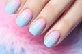 Beautiful woman\'s fingernails with pastel blue and pink ombre colored nail color design