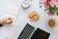 Beautiful woman`s workplace. Laptop, cookies, flowers. Flat lay.