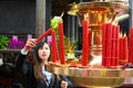 Asian woman lighting candles in Longshan Temple, Taipei, Taiwan. Beautiful young woman in Buddhist Temple