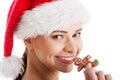 Beautiful woman in santa hat eating a cookie. Royalty Free Stock Photo