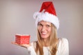 Beautiful woman with a Santa hat holding a gift box