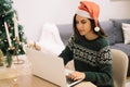 Beautiful woman with Santa hat sitting in front of a laptop Royalty Free Stock Photo