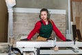 Beautiful woman sawing wooden plank in carpentry Royalty Free Stock Photo