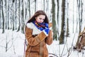 Beautiful woman in sheepskin coat in winter forest looking in mirror Royalty Free Stock Photo