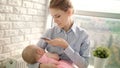 Beautiful woman in shirt taking mobile photo of girl. Mom taking photo of baby Royalty Free Stock Photo