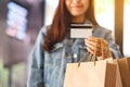 A woman with shopping bags holding and using a credit card for purchasing Royalty Free Stock Photo