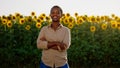 A beautiful woman with short hair is smiling widely in a perfect looking sunflower field Royalty Free Stock Photo