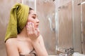 Beautiful woman after shower apply on face moisturizer. Spa, care