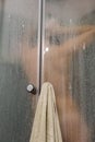 Beautiful woman in the shower behind glass with drops. woman in the shower behind glass with drops. vertical photo Royalty Free Stock Photo