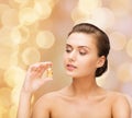 Beautiful woman showing bottle with golden dust Royalty Free Stock Photo