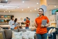 beautiful woman shows thumb holding a tablet standing in furniture store Royalty Free Stock Photo