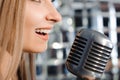 Beautiful woman singing on the stage next to the microphone.