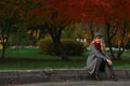 Beautiful woman sits on the road in autumn park. Royalty Free Stock Photo