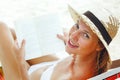 Beautiful woman sitting on beach reading a book Royalty Free Stock Photo