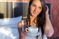 Beautiful woman sitting in bed and drinking coffee or tea the morning Royalty Free Stock Photo