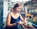 Beautiful woman sitting on cafe terrace. Panoramic street view of Da Lat city, little Paris of Vietnam