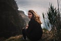 Beautiful woman sitting on a coast. View during a sunset. Location near Porto Moniz - Madeira, Portugal. Madeira, the Portuguese i Royalty Free Stock Photo