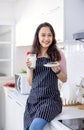 Beautiful woman sitting on kitchen tabl and drinking milk in kitchen morning