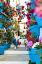 beautiful woman sitting on a ladder full of pots and flowers in an Andalusian patio Royalty Free Stock Photo