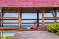Beautiful woman sitting and relaxing on a pier in the beautiful Caribbean Sea. Beach and relax Royalty Free Stock Photo