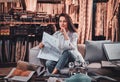 Beautiful woman is sitting on the sofa at her curtians studio Royalty Free Stock Photo