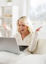 Beautiful woman sitting on the sofa using a laptop Royalty Free Stock Photo