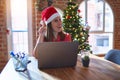 Beautiful woman sitting at the table working with laptop wearing santa claus hat at christmas pointing finger up with successful Royalty Free Stock Photo