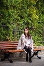 Beautiful woman sitting on a wooden bench. Walking and relaxing in the fresh air