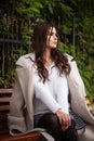 Beautiful woman sitting on a wooden bench. Walking and relaxing in the fresh air