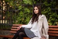 Beautiful woman sitting on a wooden bench. Walking and relaxing in the fresh air