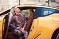 Beautiful woman sitting in a yellow sports car, close-up portrait