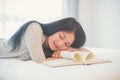 Beautiful woman sleeping on the bed sleeping after reading a book overnight Royalty Free Stock Photo