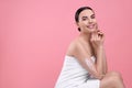 Beautiful woman with smear of body cream on her arm against pink background, space for text Royalty Free Stock Photo