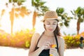 Beautiful woman smears face sunscreen at the beach for sun protection Royalty Free Stock Photo