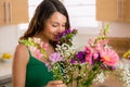 Beautiful woman smelling flowers from her lover at home on valentines day Royalty Free Stock Photo