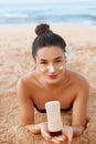 Beautiful Woman smile applying sun cream on face. Skin and  Body  care. Sun protection.Beauty  Girl in bikini holding sunscreen bo Royalty Free Stock Photo