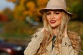 Beautiful woman smiling in autumn hat. yellow maple garden background. close-up portrait. Royalty Free Stock Photo